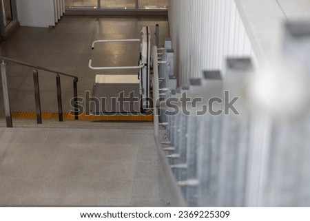 a stair lift for the disabled, wheel chair lift for stairs. Mechanical chair lift taking disabled or aged people up and down stairs. Royalty-Free Stock Photo #2369225309