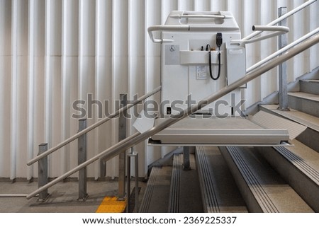 a stair lift for the disabled, wheel chair lift for stairs. Mechanical chair lift taking disabled or aged people up and down stairs. Royalty-Free Stock Photo #2369225337