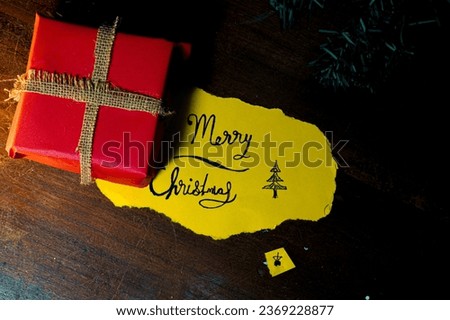 Christmas background with festive decoration and text-Merry Christmas,also space for text or copy space.christmas greetings and picture of a gift box made of paper.