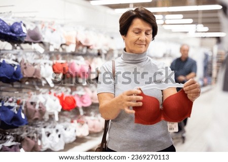Elderly woman chooses bra in store