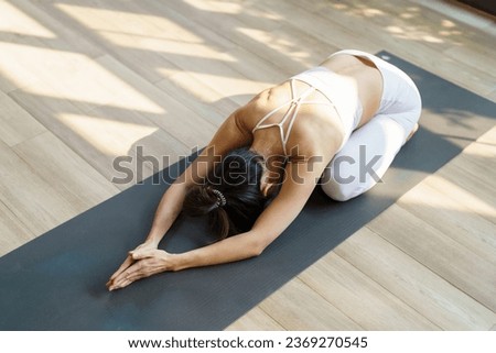 Fitness asian woman doing yoga stretching exercise on mat yoga fitness exercises. Healthy lifestyle Calmness and relax at yoga studio.