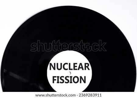 Nuclear fission symbol. Concept words Nuclear fission on beautiful black vinyl disk. Beautiful white table white background. Business science nuclear fission concept. Copy space. Royalty-Free Stock Photo #2369283911