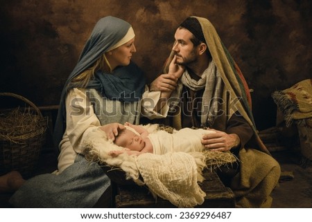 Couple reenacting a Christmas live nativity scene with their 8 days old little newborn baby Royalty-Free Stock Photo #2369296487