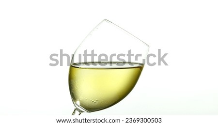 White Wine being poured into Glass, against White Background