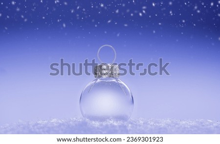 Transparent Christmas ball on a background of falling snow, space for text