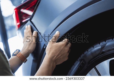 Replacing spare parts on a disassembled car in a car service garage Royalty-Free Stock Photo #2369303337