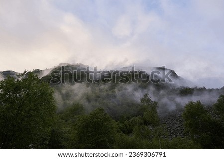 Mystic morning picture of the norwegian mountains after the night rain covered by fog and clouds. Picture is taken in the summer but cold and rainy morning, typical for scandinavian weather conditions