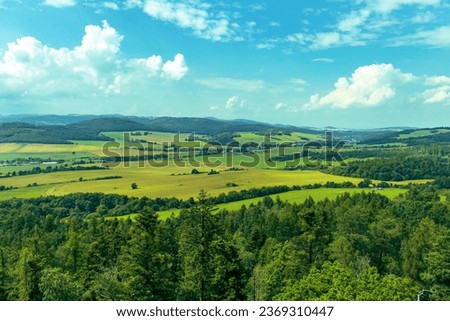 Abstract photo of beautiful nature captured from the mountain. Treetops, vast green meadows, blue sky with white clouds. Nature, sky, environment. view of mountains, forests, meadows