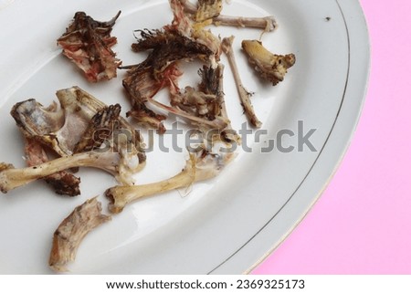 A picture of leftover chicken bones on a plate