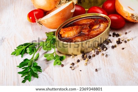 Picture of tasty stuffed squid in tomato sauce on background with greens, tomatoes and onion