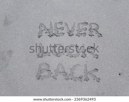 The writing never look back on the beach sand background.