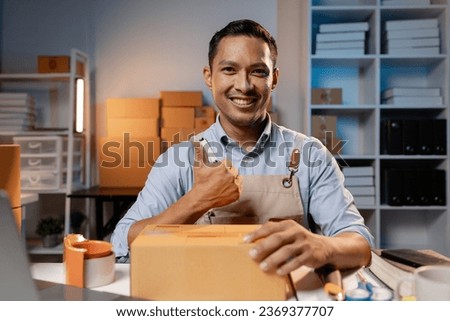 Asian business owners sell products on websites and online platforms. Business owners sell their products online and pack the products into parcels to deliver to customers via courier service. Royalty-Free Stock Photo #2369377707