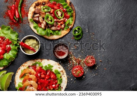 Tacos with salsa, vegetables and avocado on black background. Copy space.