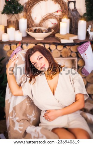 girl sitting in a rocking chair on the background of the fireplace