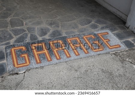garage floor ancient text in mosaic tiles at the entrance vintage