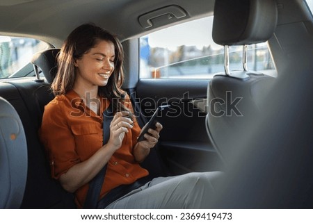 Beautiful Businesswoman is Commuting from Office in a Backseat of Her Luxury Car. Entrepreneur Passenger Traveling in a Transfer Taxi in Urban City Street Royalty-Free Stock Photo #2369419473