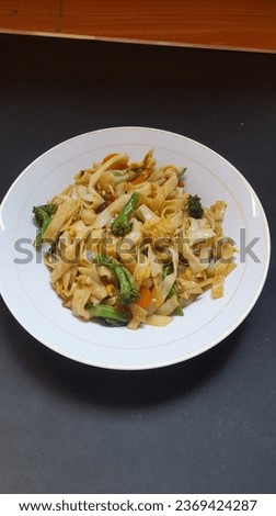 a picture of a plate of kwetiaw noodles mixed with vegetables 
