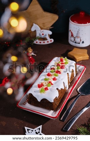 Dessert, Polish poppy seed cake with apples and candied fruits, covered with sugar icing, in Christmas style on a brown concrete background. Merry Christmas. Polish cuisine, poppy seed recipes