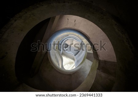 Abstract photograph of a stairwell in organic shapes, from bottom view