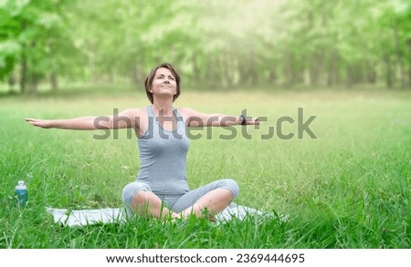 Woman doing yoga exercise outdoor in summer park. Active lifestyle concept Royalty-Free Stock Photo #2369444695