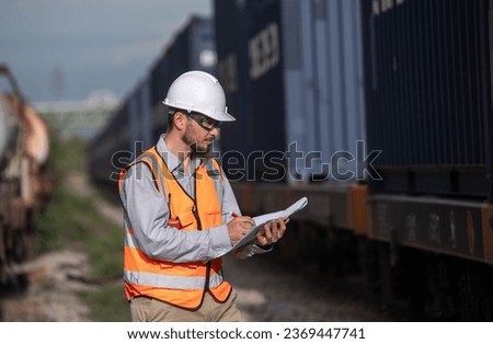 Engineers railway team wearing safety uniform and helmet under conversation document on hand inspect survey checking container railway work on railroad station is transportation industry concept Royalty-Free Stock Photo #2369447741