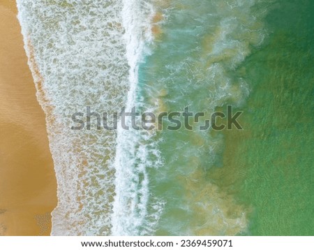 Aerial view of Waves crashing on sandy shore in sunny day,Sea surface ocean waves background,Top view beach background,Phuket Thailand
