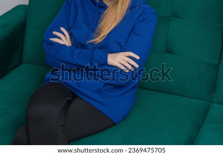 Offended teenage girl sitting on sofa during therapy with psychologist Royalty-Free Stock Photo #2369475705