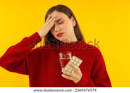 Exhausted girl in a red sweater on a yellow background.