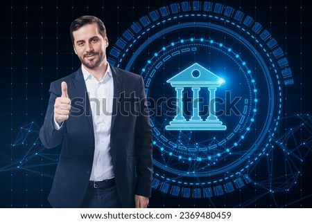Attractive young european businessman showing thumbs up with creative round polygonal banking hologram on blurry background. Digital transformation and finance concept