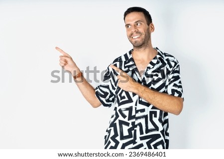 Young handsome man wearing printed shirt smile excited directing fingers look empty space