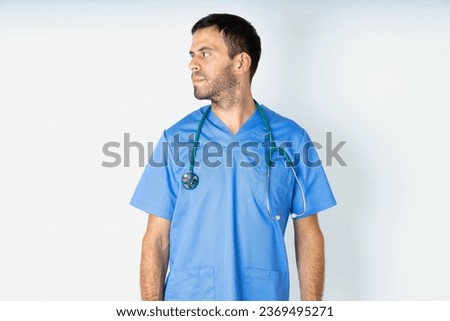 Close up side profile photo young doctor man wearing medical uniform not smiling attentive listen concentrated
