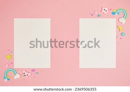 Two blank white cards on pastel pink background with frame of cute kawaii air plasticine handmade cartoon animals, stars, rainbows. Empty photo frames, baby's photo book, scrapbooking design template Royalty-Free Stock Photo #2369506355