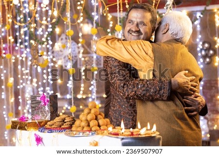 Elderly father embracing adult son on occasion of Diwali festival