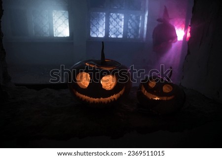 Scary Halloween pumpkin in the mystical house window at night or halloween pumpkin in night on abandoned room with window. Selective focus