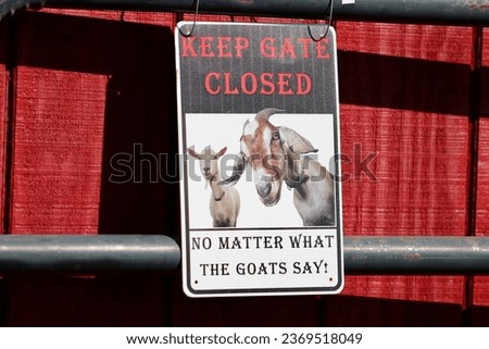 A sign that says "Keep Gate Closed No Matter What the Goat Says!".