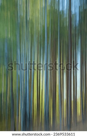Intentional camera movement (ICM) image of a dream like background of trees in forest created by motion blur.