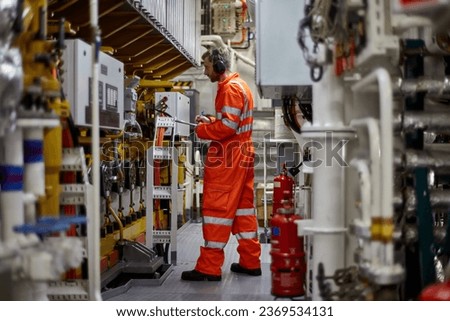 Engine officer recording working parameters of main engine. Royalty-Free Stock Photo #2369534131