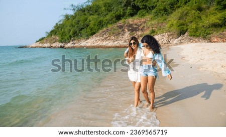 Selfie on the beach. Two friens teenager girl woman holding smart phone in hand shooting selfie photo on tropical beach. Vacation trip summer holiday.