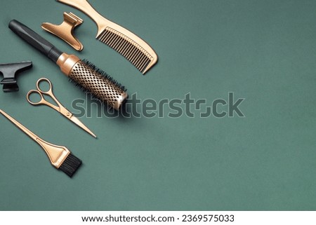 Golden hairdressing tools scissors combs on green background. Horizontal template with hair salon accessories and copy space. Royalty-Free Stock Photo #2369575033