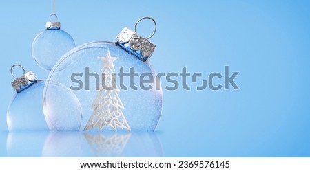 Christmas transparent balls with a Christmas tree inside on a blue background. Christmas background.