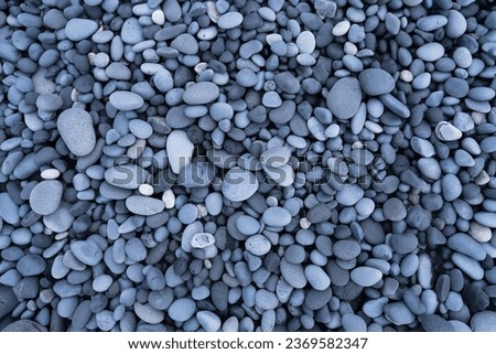 Gray pebbles as a background. Round stones on the beach. Photography for design. Textures in nature.