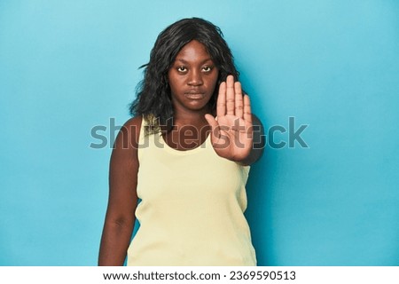 Young african american curvy woman standing with outstretched hand showing stop sign, preventing you.