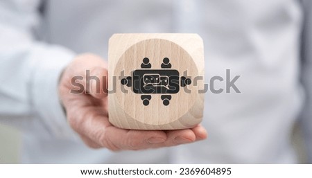 Hand holding a wooden cube with symbol of meeting concept