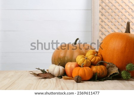 Happy Thanksgiving day. Pumpkins, autumn leaves and walnut on wooden table. Space for text