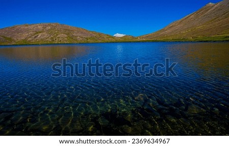 In the heart of the enchanting Deosai National Park in Skardu, Pakistan, an awe-inspiring image unveils the mesmerizing beauty of the mountain-blue waters. Here, nature paints a picture of serenity an