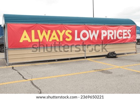 always low prices writing caption text horizontal rectangle sign banner on side of corral rain cover canopy roof