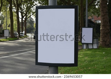 Hilversum, the Netherlands, October 2, 2023: Blanco mock up of three billboards attached to street furniture in a city street