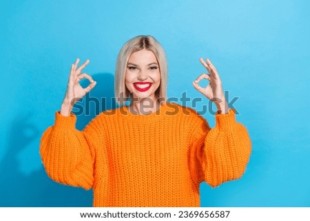Portrait of satisfied pleasant woman with bob hairstyle dressed knitwear sweater showing okey approve isolated on blue color background