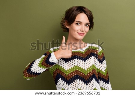Photo of pretty sweet girl dressed striped clothes showing thumb up smiling isolated green color background