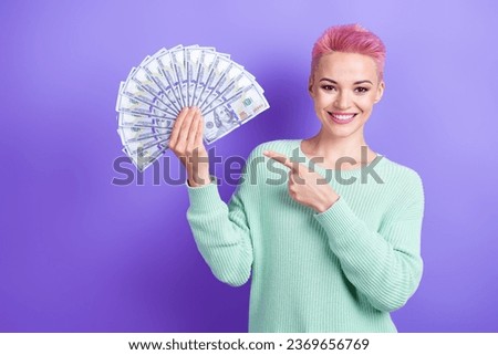 Photo of cheerful pretty girl wear turquoise sweater pointing finger money fan isolated violet color background